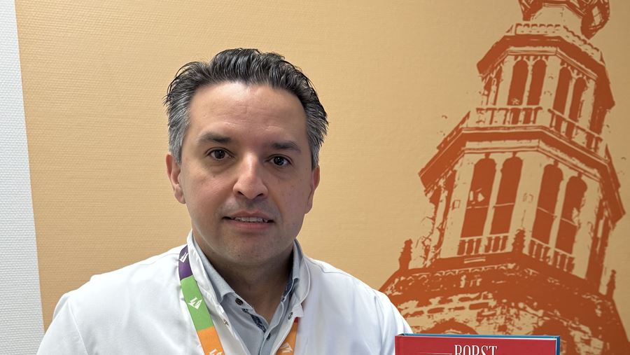 Plastisch chirurg Mahyar Foumani zit in de spreekkamer met zijn boek 'borstreconstructie uitgelegd' Plastisch chirurg Mahyar Foumani zit in de spreekkamer met zijn boek 'borstreconstructie uitgelegd'